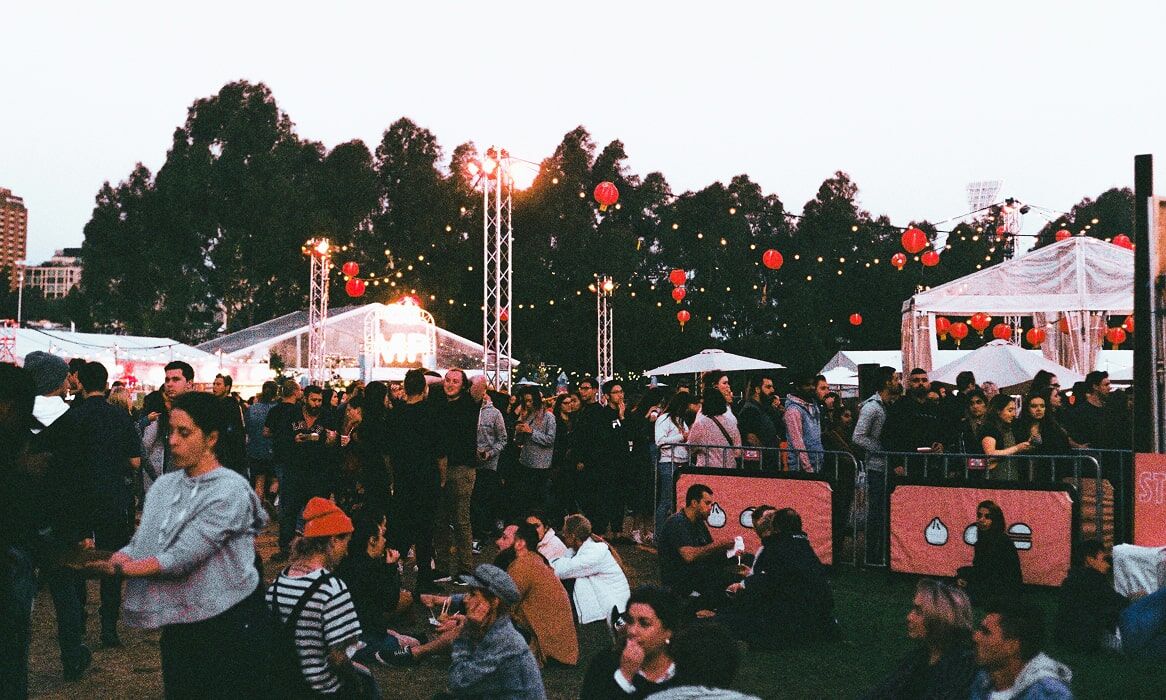 Aerial View Over GlastonBarry's festival with the main colourful yellow and blue Tent showing the surrounding forestry and coast of Barry.